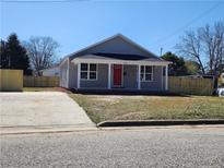 Charming single-story home with a well-manicured front yard and a welcoming red front door at 301 W Duke St, Dunn, NC 28334