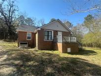 Charming brick home featuring a small front deck and a well-maintained lawn at 33 Alberta Ln, Cameron, NC 28326