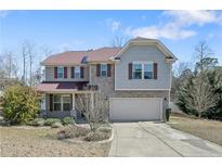 Charming two-story home featuring a stone facade, neutral siding, and a well-manicured front yard at 451 Colonist Pl, Cameron, NC 28326