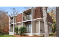 Two-story condo with brick and siding exterior, balcony, and landscaped front yard at 7036 Longstreet Dr # B, Raleigh, NC 27615