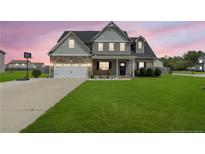 Charming two-story home with a combination of stone and siding, complemented by a well-manicured lawn at 18 Harvest Cts, Linden, NC 28356