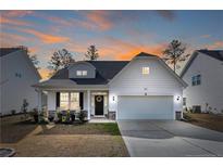 Charming home showcasing well-maintained lawn and craftsman-style design at sunset at 268 Kensington Dr, Spring Lake, NC 28390