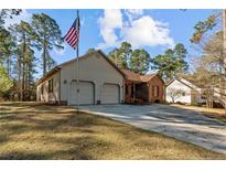 Charming home featuring a two-car garage, brick accents, and a well-manicured lawn, with an American flag on display at 51 Cedar Ln, Sanford, NC 27332