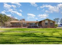 Charming single-story brick home featuring a large front lawn and multiple windows at 1010 Henley Rd, Sanford, NC 27330