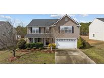 Charming two-story home with a well-manicured lawn and a two-car garage at 126 Thimbleweed Dr, Lillington, NC 27546