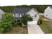 Charming two-story home with a well-maintained lawn, a two car garage, and mature landscaping at 126 Thimbleweed Dr, Lillington, NC 27546