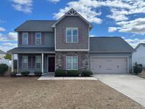 Charming two-story home featuring a two-car garage, and a blend of stone and siding accents at 43 Battery Way, Bunnlevel, NC 28323