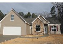 Charming single Gathering home features a stone front, attached garage, and newly poured concrete driveway at 261 River Falls Rd, Sanford, NC 27332