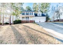 Charming two-story home featuring a manicured lawn, attached two-car garage and welcoming front porch at 336 Richmond Park Dr Dr, Cameron, NC 28326