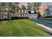 Charming two-story home with a well-manicured lawn and two-car garage at sunset at 336 Richmond Park Dr Dr, Cameron, NC 28326