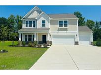 Charming two-story home with a well-manicured lawn and an attached two-car garage at 91 Walker Grove Ln, Lillington, NC 27546