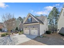 Two-story home with a two-car garage, stone accents, and neutral siding at 1031 Micah'S N Way, Spring Lake, NC 28390