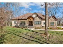 Charming stone and siding home with a manicured lawn and covered front porch at 26 Traceway, Sanford, NC 27332
