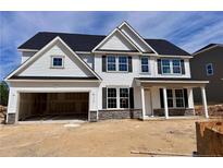 New two-story home with a two-car garage, stone accents, and a covered front porch in a residential area at 120 Steeple Rdg, Cameron, NC 28326