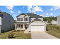 Charming two-story home with a manicured lawn, inviting entrance, and attached two-car garage at 183 Hallow Oak St, Spring Lake, NC 28390