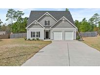 Charming two-story home with a gray exterior, two-car garage, and a well-maintained lawn at 405 Turriff Way, Cameron, NC 28326