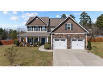 Charming two-story home featuring a stone facade, manicured lawn, and an attached two-car garage at 480 N Prince Henry Way, Cameron, NC 28326