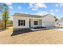 New construction featuring white siding, black shutters, manicured lawn, and attached two car garage at 4955 Ray Rd, Spring Lake, NC 28390