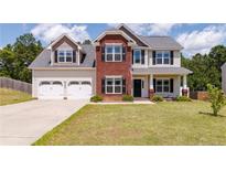 Charming two-story home with a well-maintained lawn and a spacious two car attached garage at 519 Wood Point Dr, Lillington, NC 27546