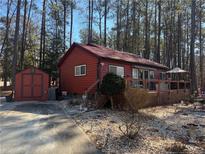 Charming single-story home with a deck and a storage shed in a wooded setting at 972 High Harbor Rd, Sanford, NC 27332