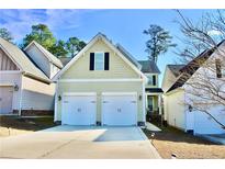 Charming home featuring a two-car garage and landscaped front yard on a sunny day at 1477 Micahs Way N, Spring Lake, NC 28390