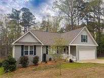 Charming single-story home featuring gray siding, dark shutters, and a well-manicured front yard at 1504 Kentucky Ave, Sanford, NC 27332