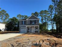 Charming two-story home with gray siding, a one-car garage, and a welcoming front porch at 205 Regis Ln, Coats, NC 27521
