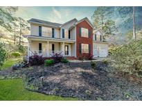 Charming two-story home featuring a brick accent, manicured lawn, and inviting front porch at 172 Green Links Dr, Cameron, NC 28326