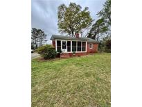 Charming single-story home with brick exterior and a cozy screened-in front porch at 216 Pendergraft Rd, Bunnlevel, NC 28323