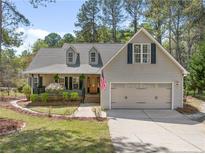 Charming home featuring a manicured lawn, a two-car garage, and a welcoming front porch at 76 Silver Lake Pt, Sanford, NC 27332