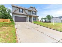Charming two-story home featuring a spacious driveway and attached garage, perfect for a growing Gathering at 10 N Dakota Ct, Spring Lake, NC 28390