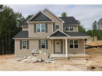 Charming new construction home featuring neutral siding, dark shutters, and an inviting covered front porch at 106 Driftwood Ct, Sanford, NC 27330