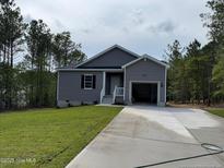 Charming single-story home featuring a gray exterior, a one-car garage, and a well-maintained lawn at 182 Horse Trot Ln, Sanford, NC 27332