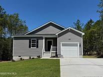 Charming single-story home with gray siding, manicured lawn, and attached one-car garage at 182 Horse Trot Ln, Sanford, NC 27332