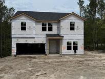 Two-story home featuring an unfinished exterior with visible house wrap and a two-car garage at 204 Horse Trot Ln, Sanford, NC 27332