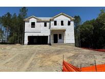 Unfinished two-story home with attached garage, shown with exposed construction materials on a sunny day at 28 Horse Trot Ln, Sanford, NC 27332