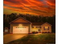 Charming single-Gathering home with a two-car garage and well-manicured lawn, set against a dramatic sky at 40 Patricia S Vann Ct, Dunn, NC 28334