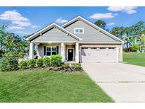 Charming single-story home with well-manicured lawn, attached garage, and inviting covered front porch at 276 Widgeon Way, Lillington, NC 27546