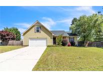 Charming home boasts a well-maintained lawn, two-car garage, and classic architectural details on a sunny day at 45 Ridgecrest Rd, Cameron, NC 28326