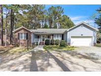 Charming single-story home with a brick and siding exterior, manicured landscaping, and a two-car attached garage at 6138 St Andrews Dr, Sanford, NC 27332