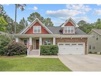 Charming two-story home with a manicured lawn, covered porch, stone accents, and an attached two-car garage at 85 Heatherspring Way, Spring Lake, NC 28390