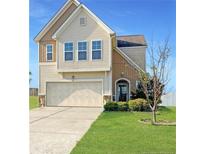 Charming two-story home with a well-manicured lawn, attached garage, and classic architectural details at 94 Red Coat Dr, Cameron, NC 28326