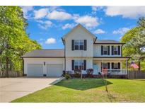 Charming two-story home with a welcoming front porch and well-manicured lawn at 940 Lakeridge Dr, Cameron, NC 28326