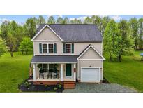 Charming two-story home with a well-manicured lawn and inviting front porch, perfect for relaxing outdoors at 240 Carr Store Rd, Cedar Grove, NC 27231
