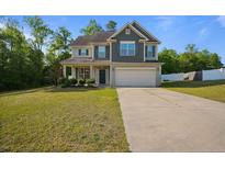 Charming two-story home with a well-manicured lawn and a two-car garage at 34 Coswell Ct, Cameron, NC 28326