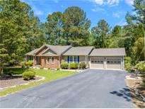 Charming single-story home with a well-manicured lawn, brick accents, and an attached two-car garage at 6044 Saint Andrews Dr, Sanford, NC 27332
