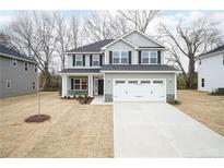 Charming two-story home featuring a gray exterior, a two-car garage, and a well-manicured front lawn at 111 Southern Estates Dr, Sanford, NC 27330