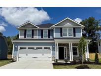 Charming two-story home featuring a stone accents, attached two-car garage, and a well-manicured lawn at 119 Southern Estates Dr, Sanford, NC 27330