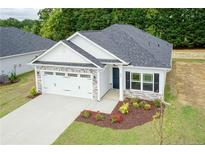 Charming single-story home with a two-car garage, manicured lawn, and tasteful landscaping at 214 Drayton Hall Ln, Sanford, NC 27330