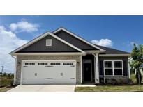 Charming single Gathering home featuring a stone facade, two-car garage and manicured lawn at 214 Drayton Hall Ln, Sanford, NC 27330